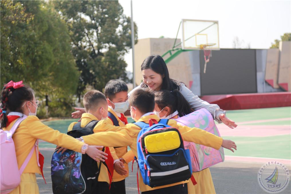 少先队大队辅导员杨绘春老师拥抱回校孩子们.jpg